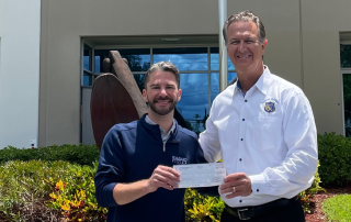 Senior Marketing Manager Chris Concepcion presents SFPBA Executive VP David Greenwell with the SFPBA Love Fund donation check